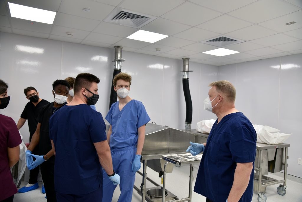 A group of students in the anatomy lab being instructed.