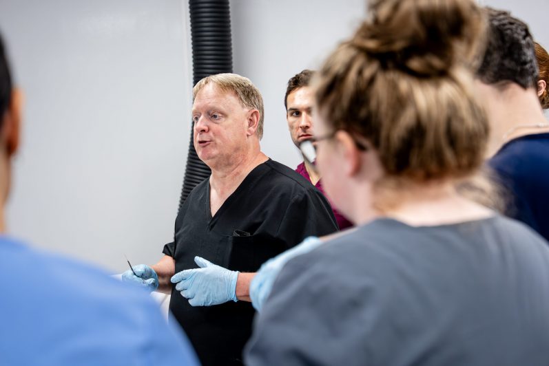 A group of students being instructed in the anatomy lab.