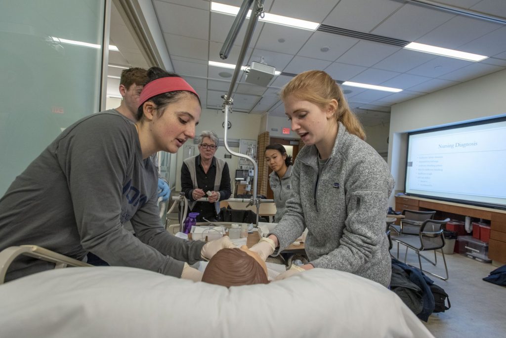Two students in the Pre-College Summer Program examining a medical model. 